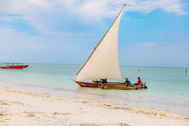 Einheimische im Boot vor Strand